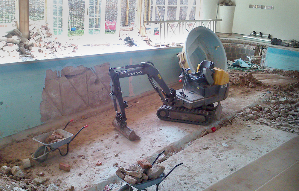 strip out demolition using a mini-digger inside a derelict factory